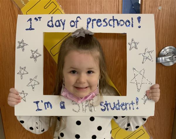 This picture is of MV on her first day of HP Preschool holding a first day sign.
