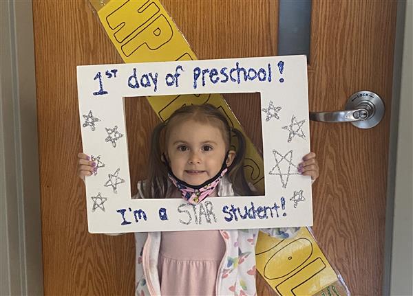 This picture is of VG on her first day of HP Preschool holding a first day sign.
