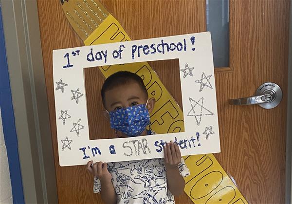 This picture is of OR on his first day of HP Preschool holding a first day sign.